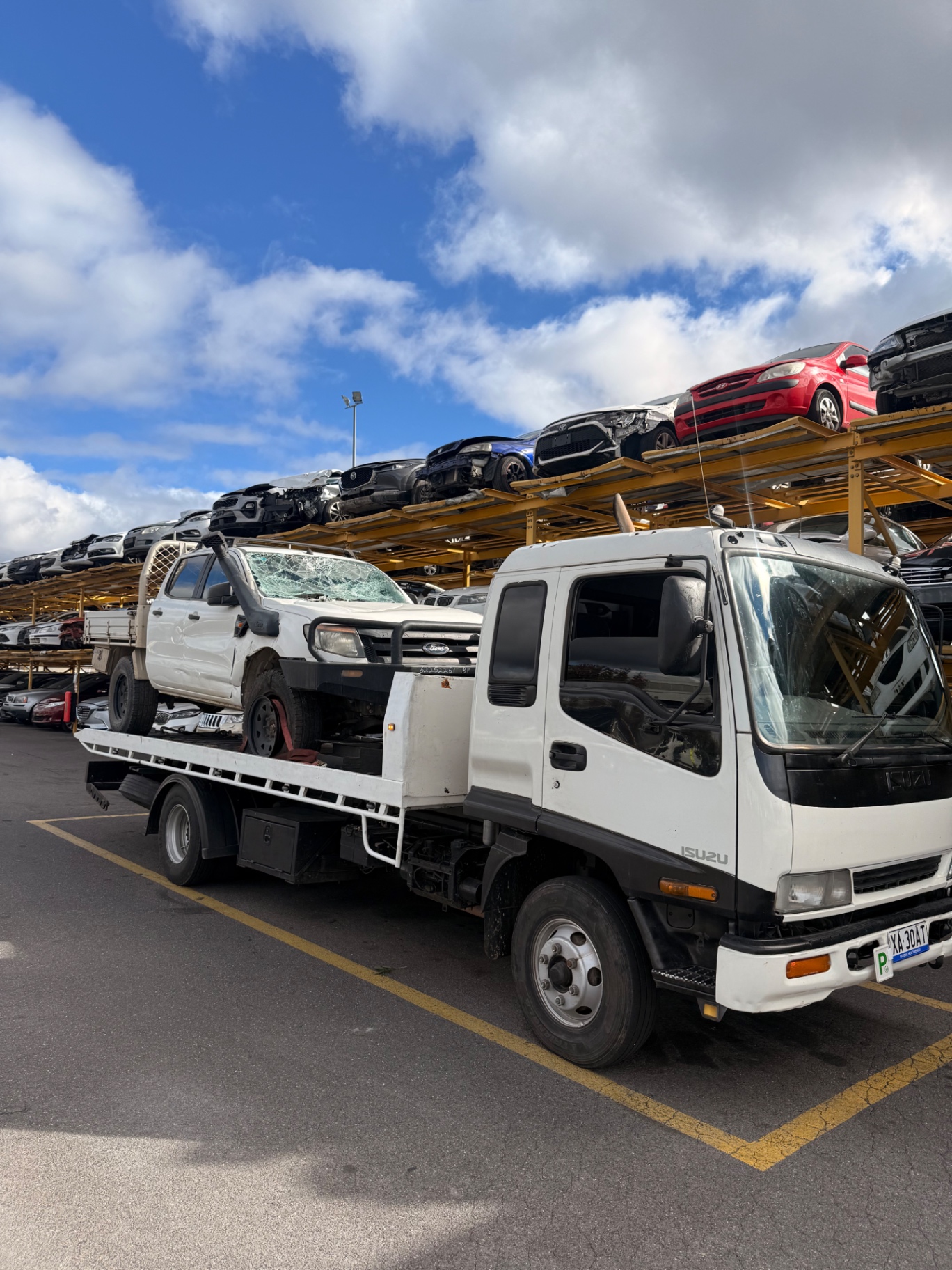 Junk car being loaded onto flatbed for scrap removal
